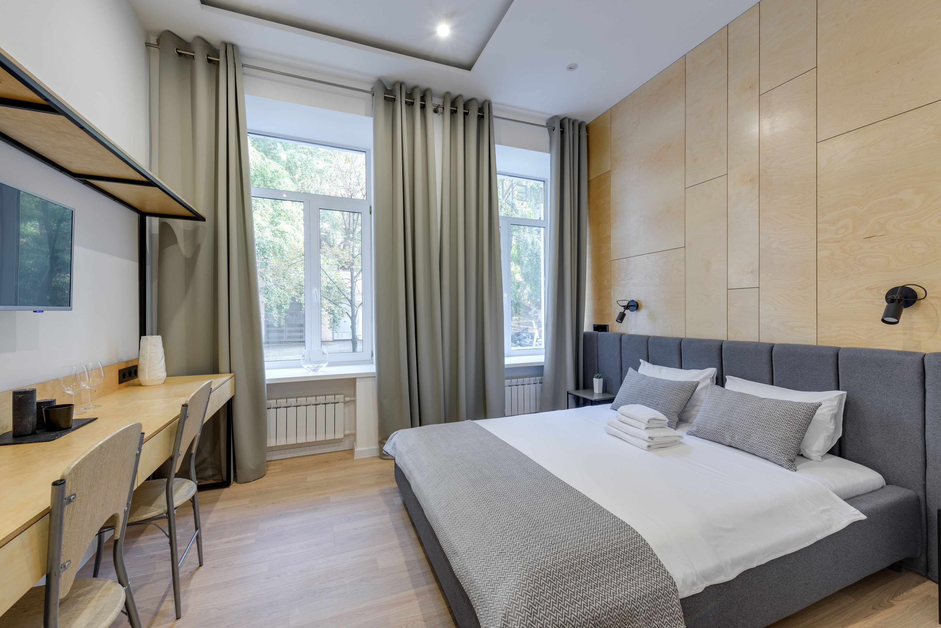 Une chambre moderne avec un grand lit, un bureau et une télévision.