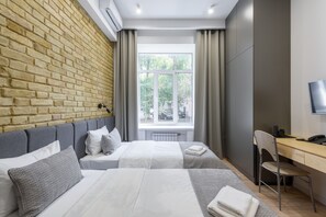 Een hotelkamer met twee bedden, een bureau, een stoel en een televisie.