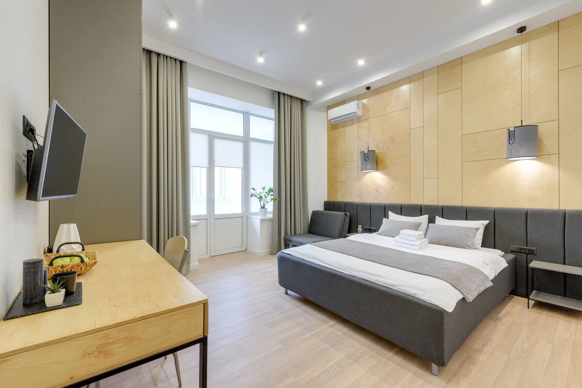 Um quarto moderno com uma cama grande, uma escrivaninha e uma televisão.