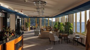 A spacious lounge area with a view of the sea, a reception desk, and modern furnishings. - Villa Malo More (Dubrovnik)