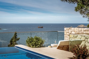 A pool with a view of the sea and a ship in the distance. - Villa Malo More (Dubrovnik)