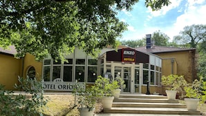 A hotel entrance with a sign reading "ENZO HOTELS" and "HOTEL ORION".