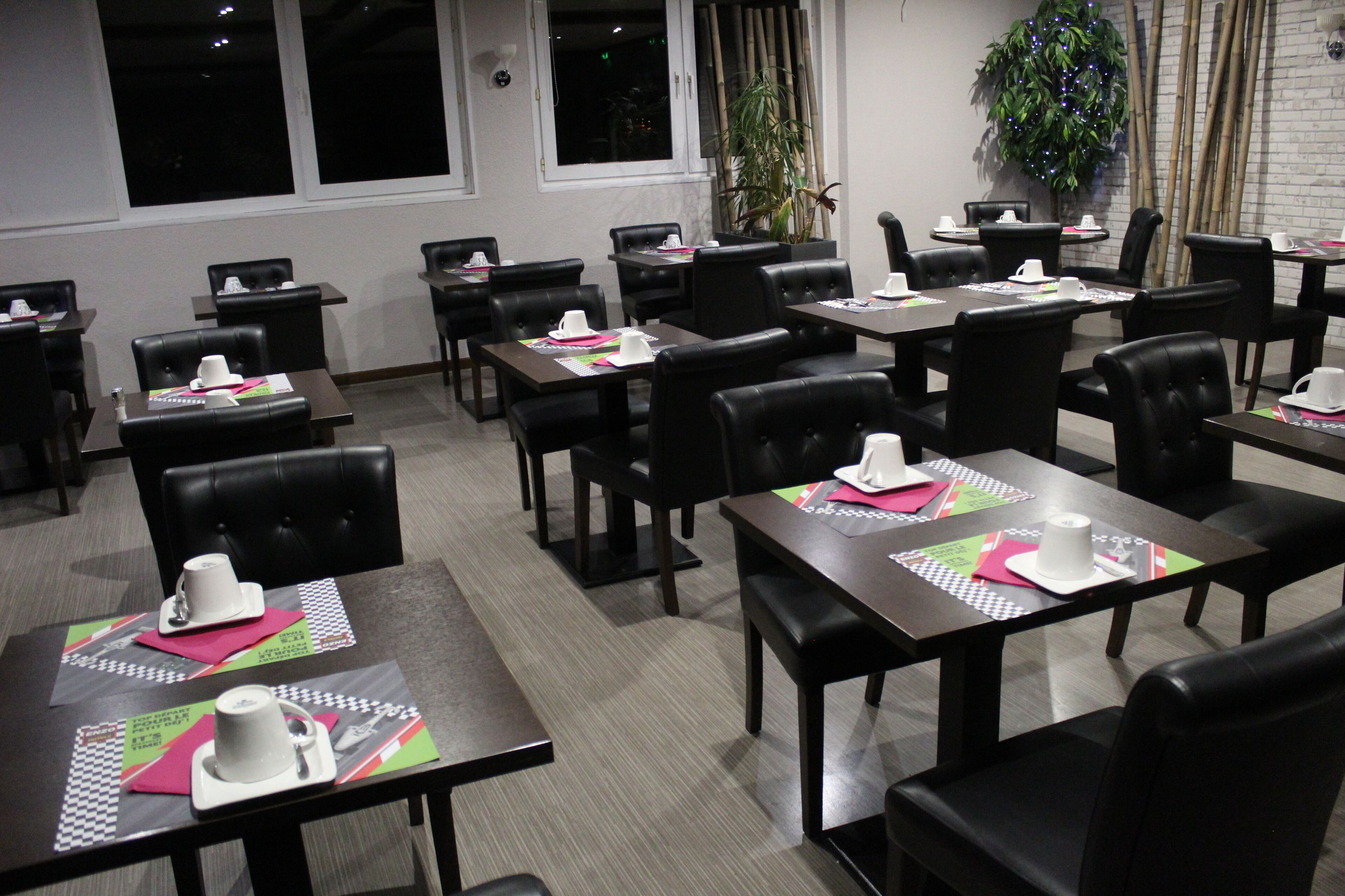 Une salle de conférence avec des tables disposées pour les réunions, équipée de plaques nominatives et de matériel de bureau.