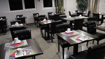 Une salle de conférence avec des tables disposées pour les réunions, équipée de plaques nominatives et de matériel de bureau.