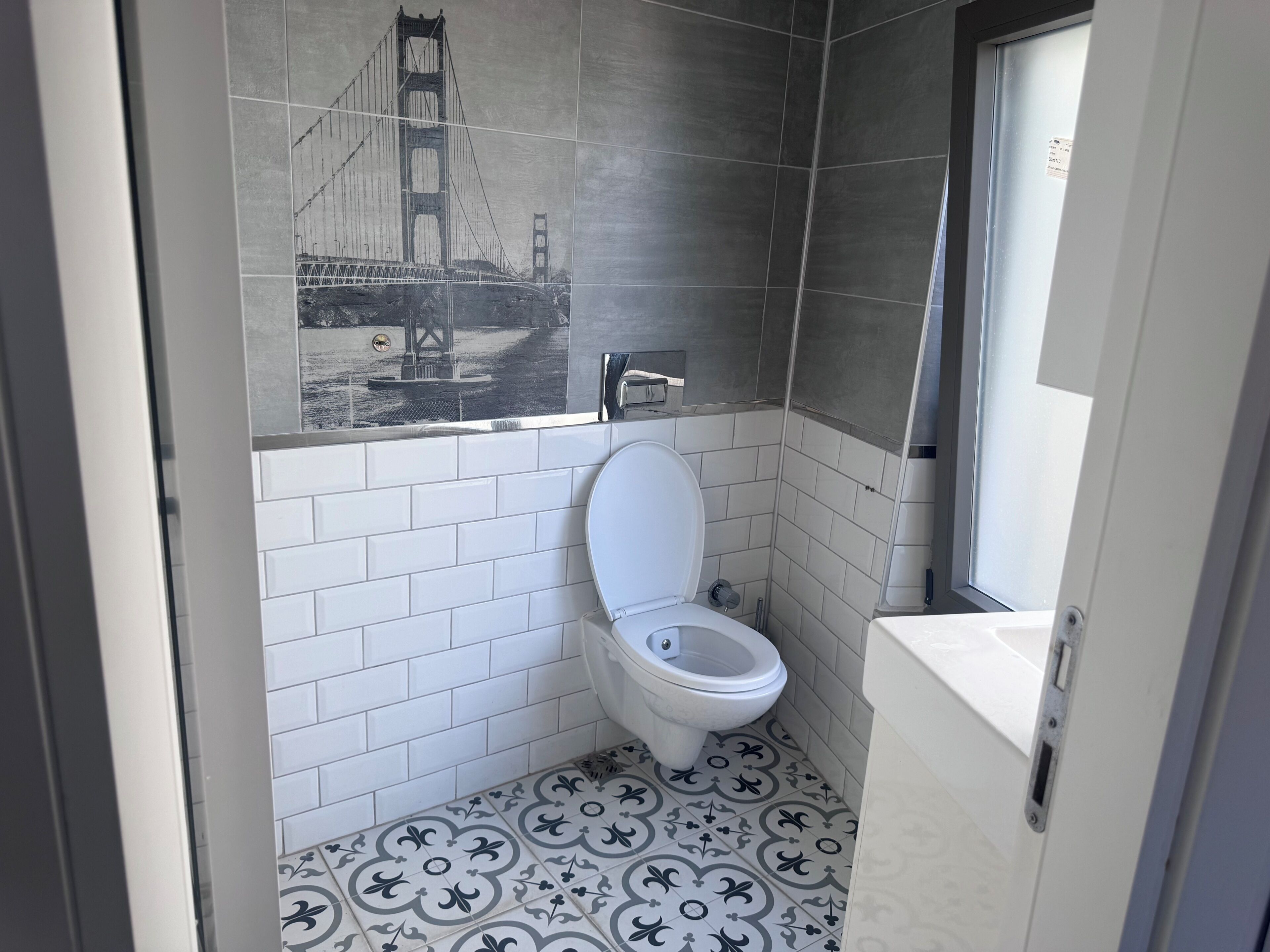 Un baño con inodoro blanco, lavamanos y zona de ducha.