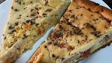 A slice of quiche on a white plate.