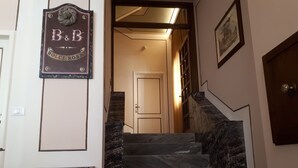A staircase with marble steps leading to a door. A sign above the stairs reads "B&B DOLCE ROSSA". - Dolce Rosa  Centro Storico (Sansepolcro)
