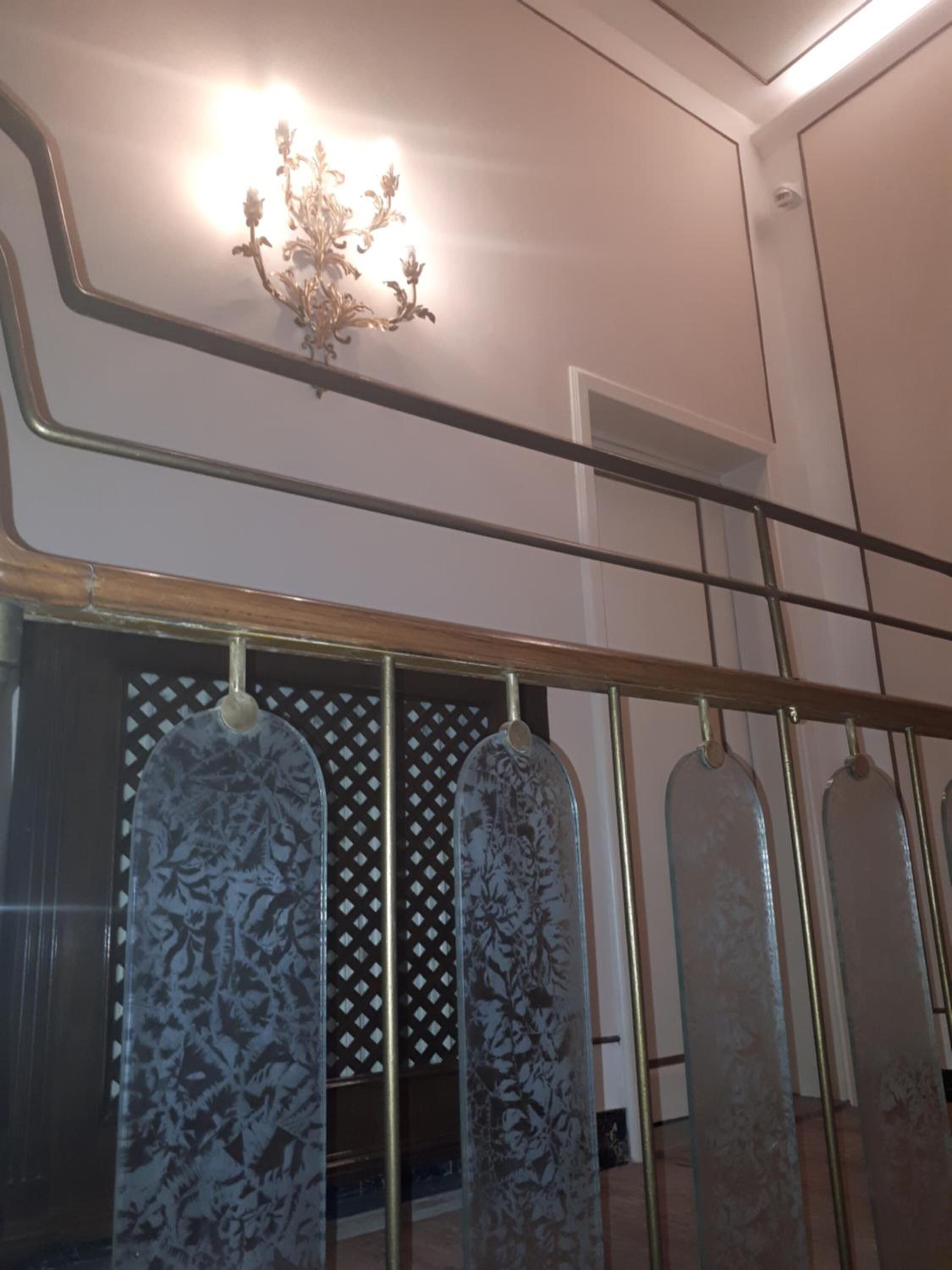 Un escalier avec une rampe en métal et des panneaux de verre décoratifs.