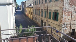 A narrow street with historic buildings, a balcony with potted plants, and a no parking sign. - Dolce Rosa  Centro Storico (Sansepolcro)