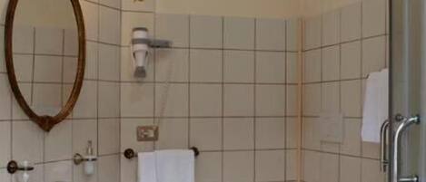 Un baño con lavamanos pedestal, espejo, toallero, inodoro y bidé.
