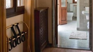 A hallway leading to a bathroom with a radiator, a towel rack, and a light fixture. - Dolce Rosa  Centro Storico (Sansepolcro)