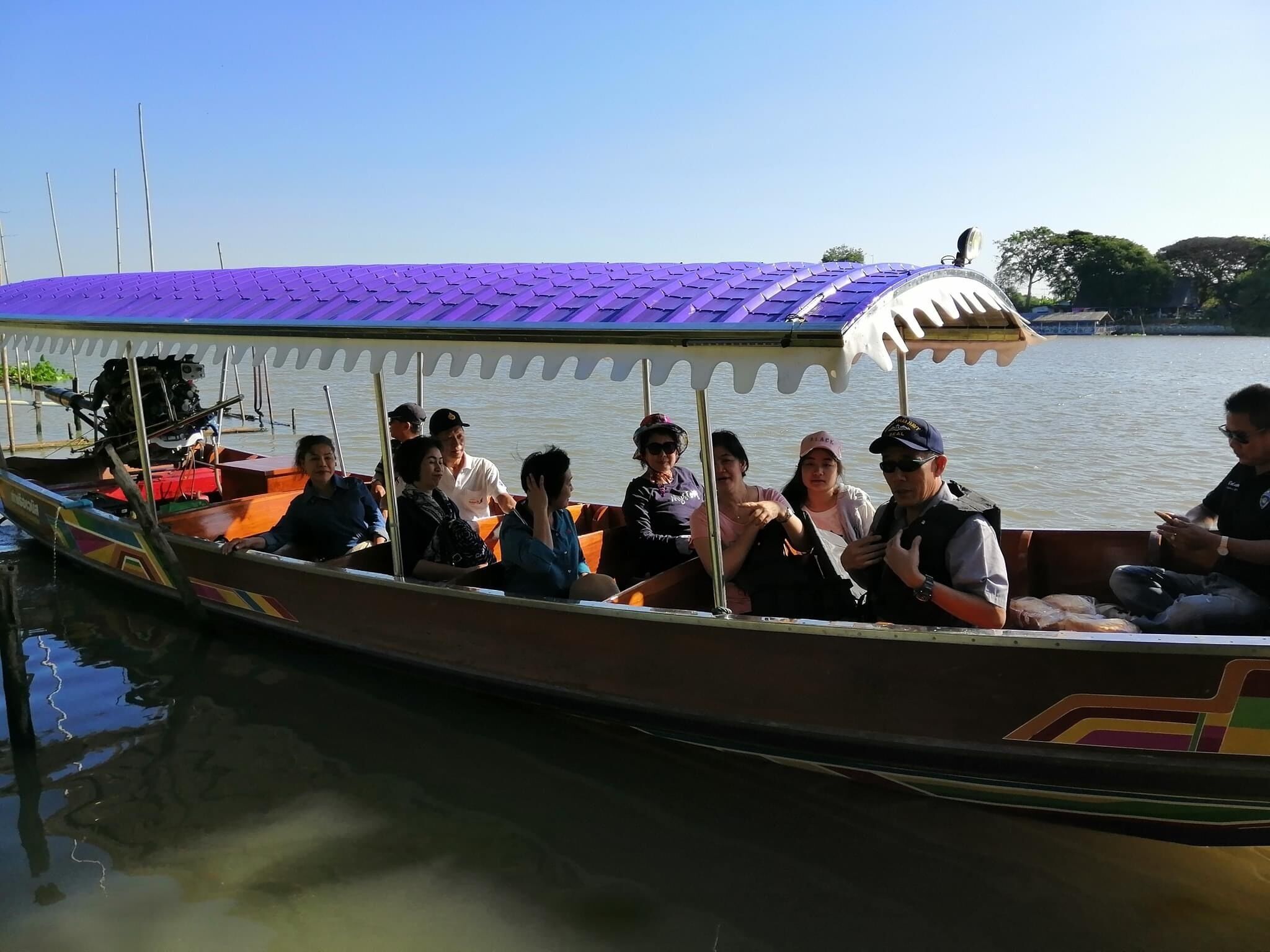 A boat with a purple roof and passengers.