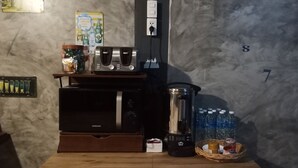 A kitchen area with a microwave, toaster, blender, and a shelf with jars and bottles. - Lom Choi Home Stay Ayutthaya - Hostel (Ayutthaya)