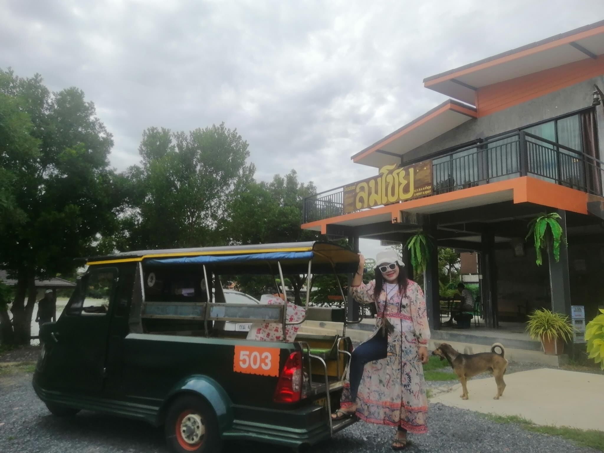 Un tuk-tuk est garé devant un immeuble sur lequel on peut lire l’inscription « Anan ».