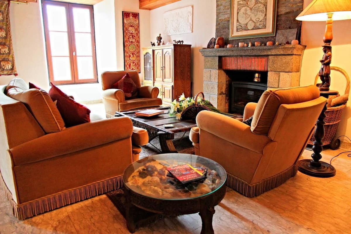 A cozy living room with two armchairs, a coffee table, and a fireplace.