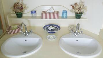A bathroom with two sinks, a mirror, and shelves with toiletries.