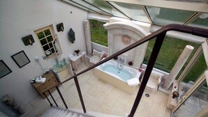 Une salle de bain luxueuse avec une baignoire îlot, une douche à l’italienne et un lavabo en marbre.