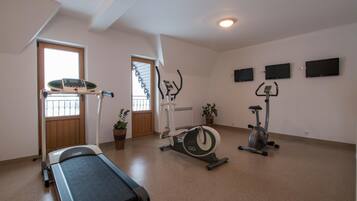 Un gimnasio con cinta de correr, elíptica y bicicleta estática.