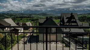 A residential area with houses, a gravel driveway, and a mountain range in the background. - Dom Wypoczynkowy U Staszla (Szaflary)