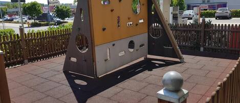 An outdoor climbing structure with a metal frame and climbing holds.