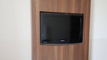 Un téléviseur Samsung fixé au mur dans une pièce aux murs lambrissés.