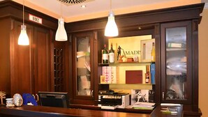 Un mostrador de recepción con detalles de madera, un letrero de BMZ encima y una vitrina de vidrio con varios objetos.