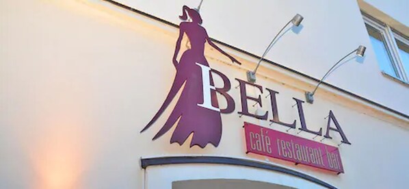 A building with a sign that reads "BELLA café restaurant bar".
