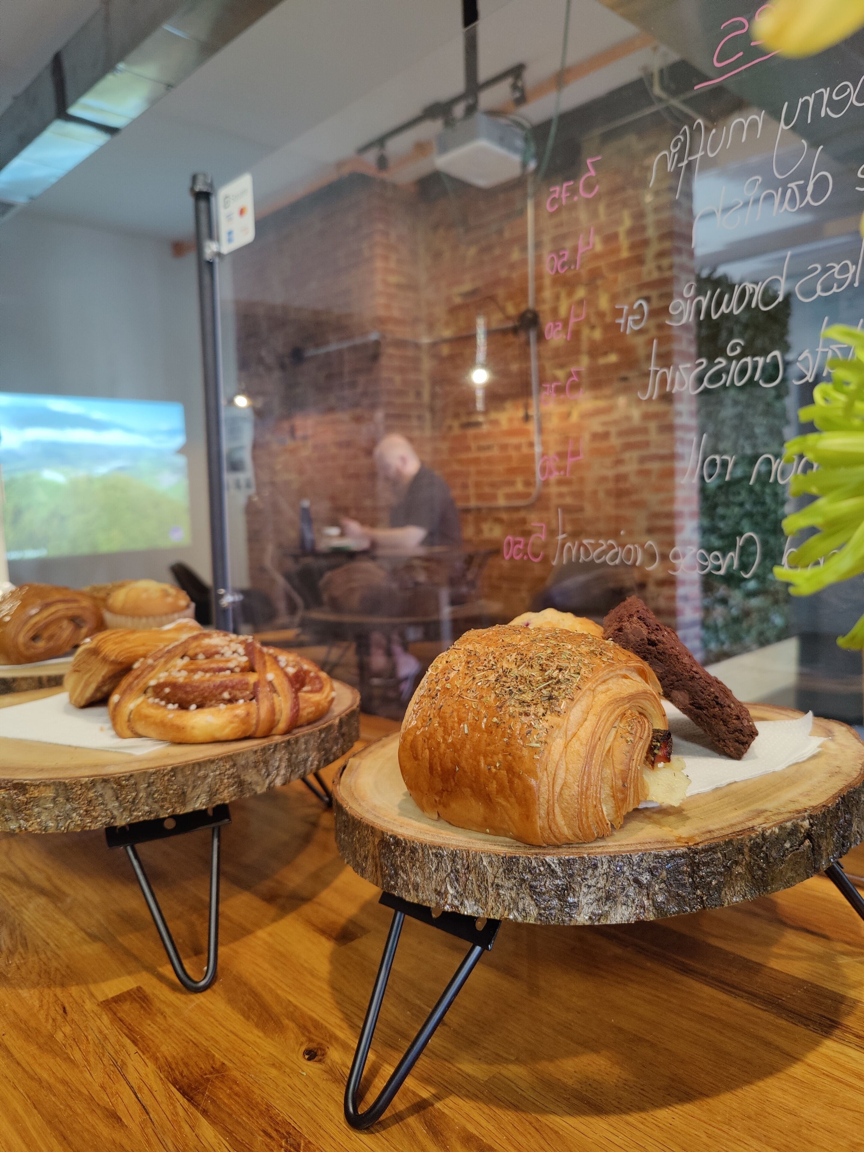 A bakery display with various pastries on wooden boards.
