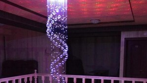 A bar area with a stone counter, bar stools, and a hanging light fixture. - Zelenaj Dacha (Drahobrat)