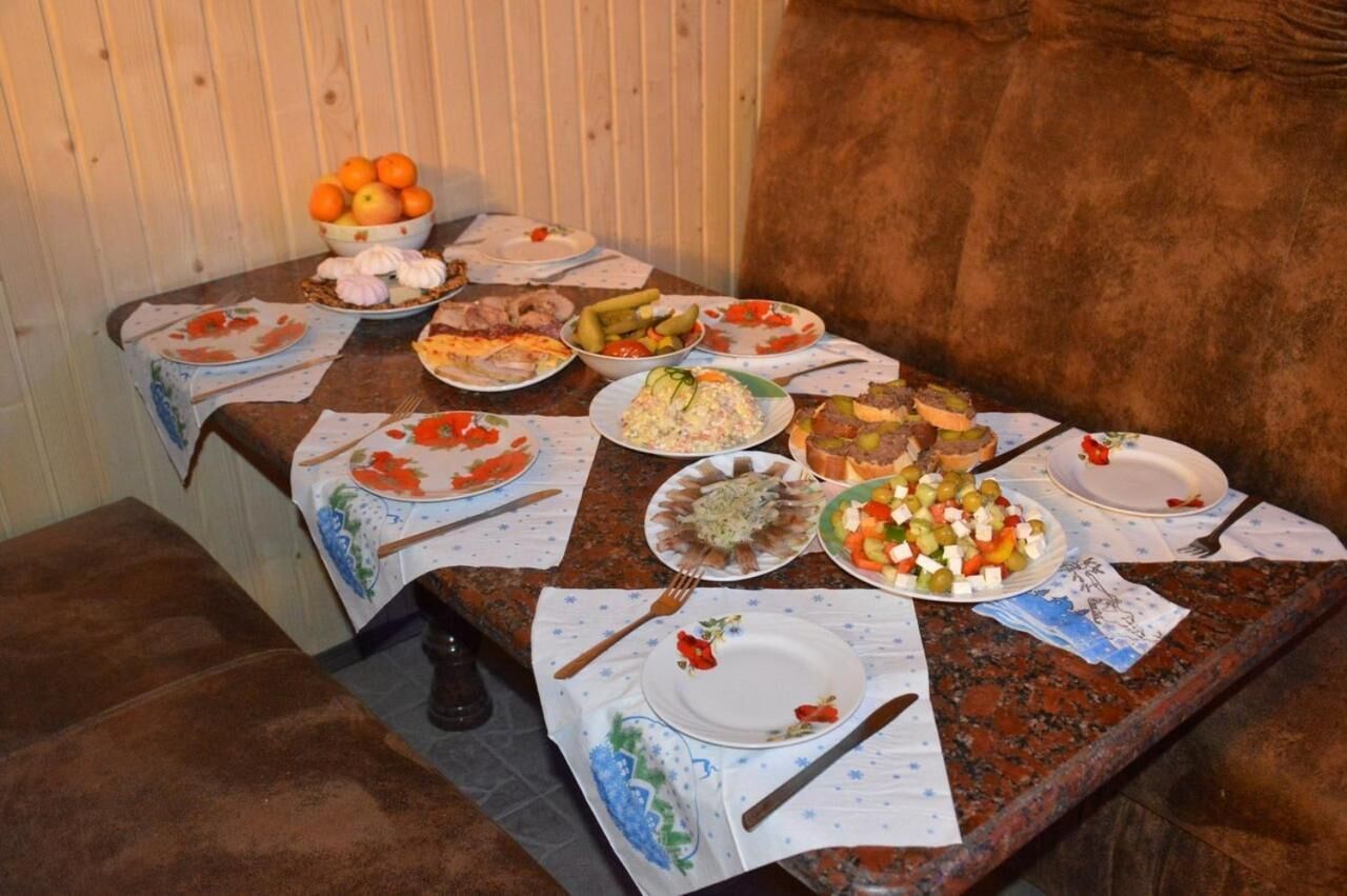A dining table with various dishes and a bowl of oranges.