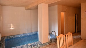 A wooden interior with a tiled pool area and a wooden bench. - Zelenaj Dacha (Drahobrat)