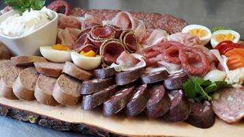 Une planche de charcuterie avec différentes sortes de viandes, d’œufs et de fromages.