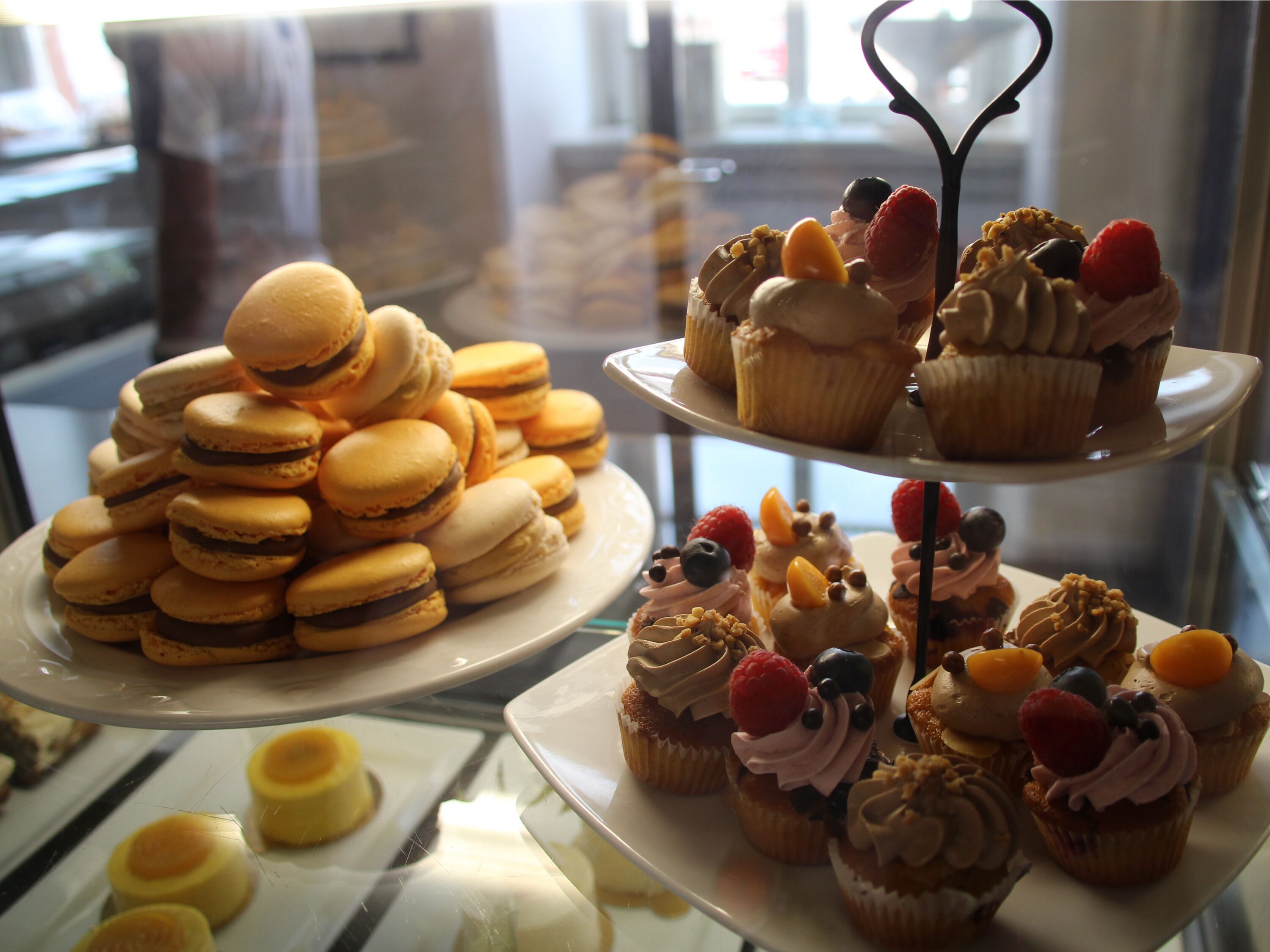 Eine Auswahl an Desserts, darunter Macarons und Cupcakes mit verschiedenen Toppings.
