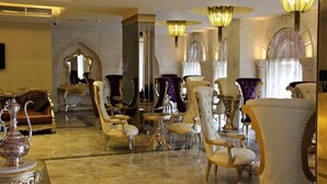 A luxurious lobby with ornate furniture, chandeliers, and a grand mirror. - Kasr-ı Sercehan Hotel (Nusaybin)