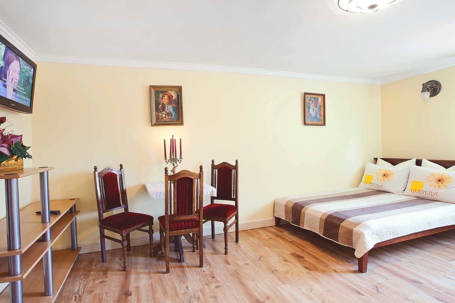 Un dormitorio con una cama, dos sillas, una mesa y un candelabro.