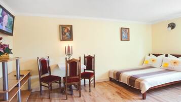 Un dormitorio con una cama, dos sillas, una mesa y un candelabro.
