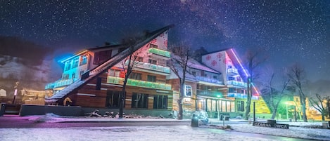 Un hotel de varios pisos con una escalera que conduce a los pisos superiores, rodeado de nieve.