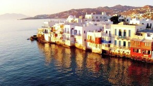 A coastal town with white buildings along the waterfront. - Mykonian Breeze (Mykonos)