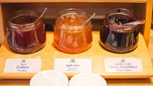Three jars of jam on a wooden display with labels. - Hotel Am Bismarck (Mannheim)