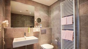 A modern bathroom with a sink, toilet, and a towel rack. - Hotel Am Bismarck (Mannheim)