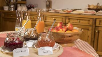 Ein Frühstücksbuffet mit verschiedenen Marmeladen und Früchten.