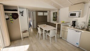 A compact kitchen with a dining table, white chairs, a microwave, and a dishwasher. - Domaine De Verdagne (Gassin)