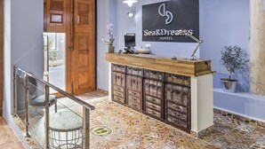 Una mesa de recepci ón con mostrador de madera y un cartel que dice "Sea&Dream Hostel".