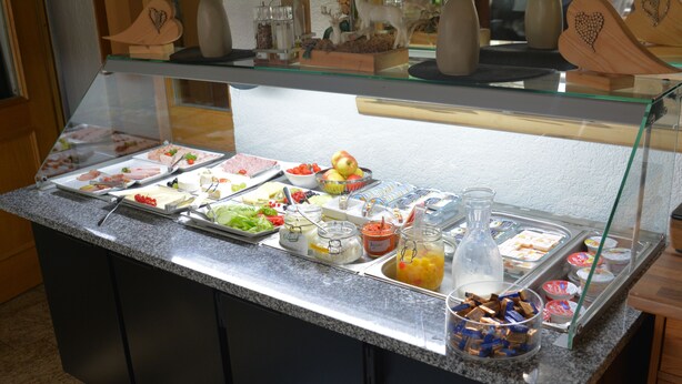 Un bufé con distintos alimentos y recipientes.