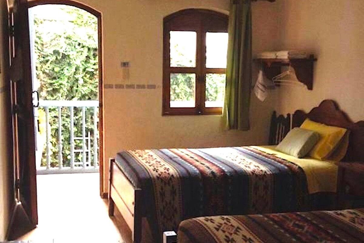 A bedroom with a bed, a window, and a door leading outside.
