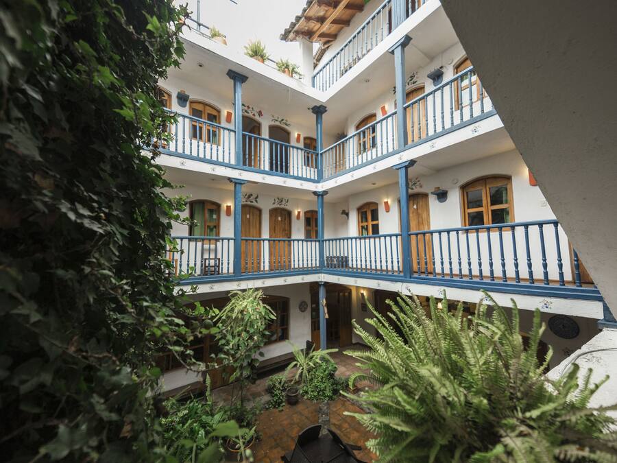 A multi-level courtyard with balconies, potted plants, and a central fountain.
