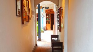 A corridor with a tiled floor leading to a restaurant. - Hotel Doña Esther (Otavalo)