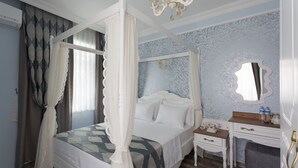A four-poster canopy bed with white bedding, a bedside table with a telephone, and a mirror on the wall. - Zeynep Hatun Otel (Biga)