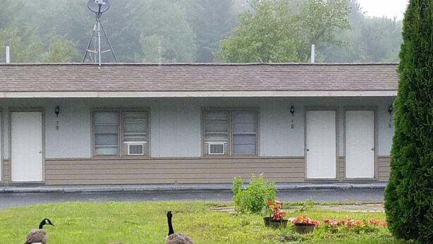 A building with a flat roof, multiple windows, and a satellite dish. - Becket Motel (Becket)
