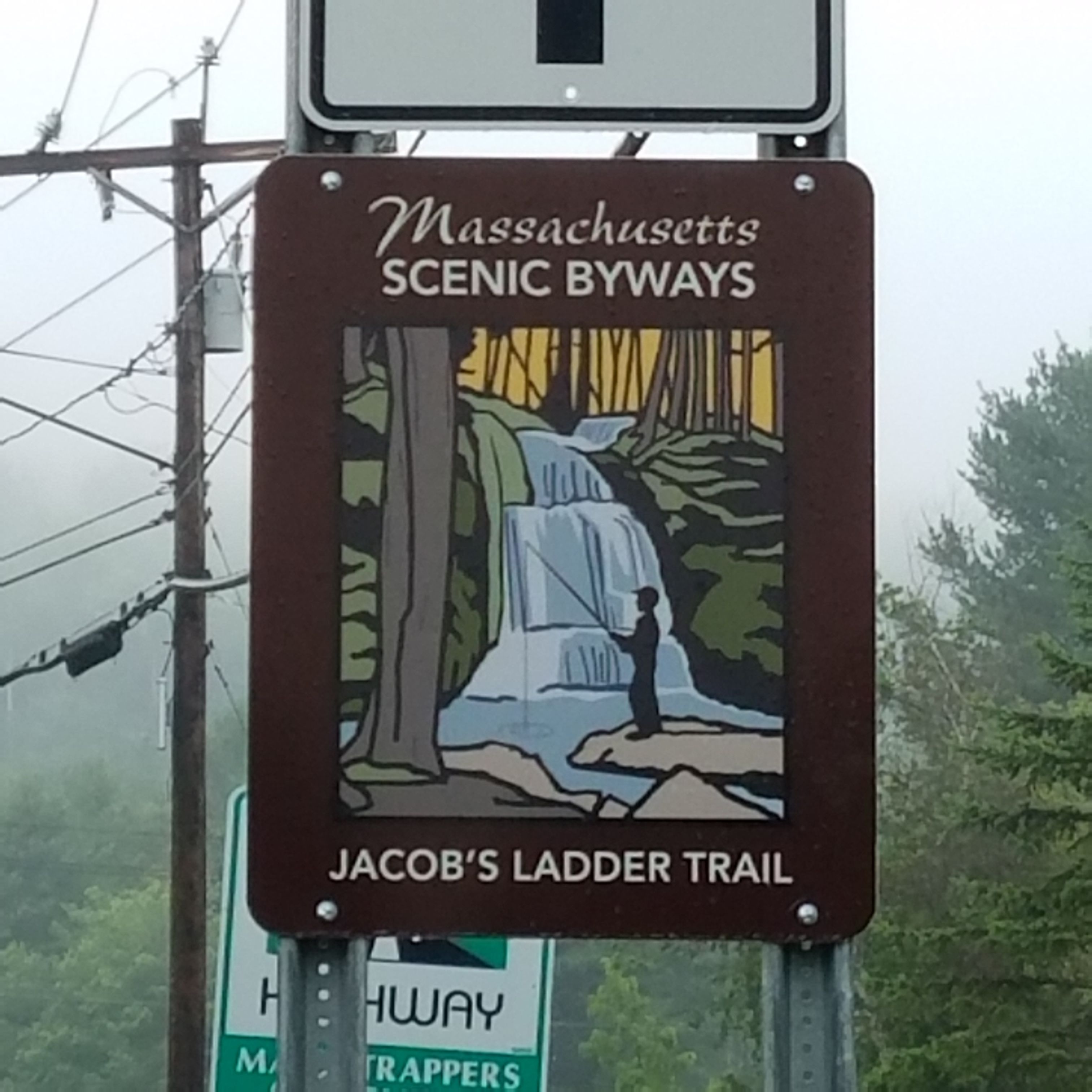 Placa para as Estradas Panorâmicas de Massachusetts, com ilustração de uma cachoeira e um caminhante.